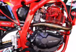 Red dirt bike engine with exhaust pipe and frame
