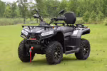 Black 4x4 ATV parked on green grass field