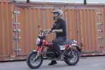 Rider on red mini motorcycle with helmet