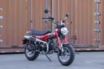 Red Dax style mini motorcycle parked outdoors