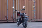 Red mini motorcycle parked by shipping container