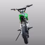 Vista trasera de una moto de cross verde con escape y neumático con tacos.