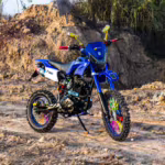 Motocicleta azul com raios coloridos nas rodas em terreno rochoso