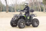 Rider on black and green ATV in outdoor setting