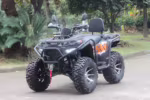 Quadriciclo preto e laranja com pneus grandes estacionado ao ar livre