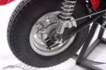Roda traseira de motocicleta com aro cromado e amortecedor.