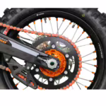 Motorcycle rear wheel with orange chain and sprocket