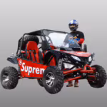 Red off-road dune buggy with driver wearing helmet