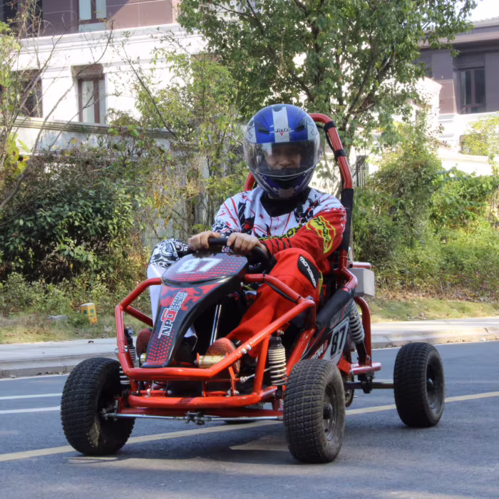 Persona conduciendo un kart todoterreno rojo en la calle.