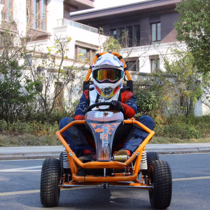 Piloto con casco conduciendo un kart todoterreno naranja