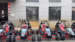 Off-road go-karts parked outside industrial building