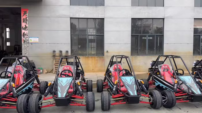 Karts todoterreno estacionados frente a un edificio industrial.