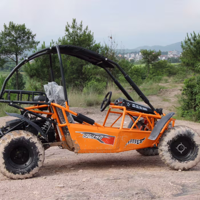 Kart todoterreno naranja con jaula antivuelco en un camino de tierra.