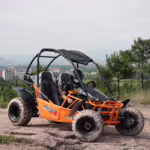 Orange off-road go-kart with driver on rocky terrain