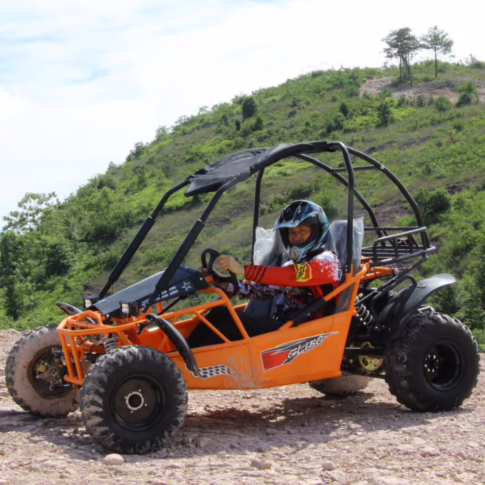 Kart todoterreno naranja con conductor en terreno rocoso