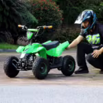Green mini ATV quad bike with rider in helmet
