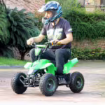 Rider on green mini ATV quad bike outdoors