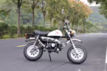 White Honda mini motorcycle parked on road