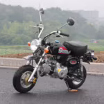 Mini motocicleta preta com decalques quadriculados estacionada ao ar livre