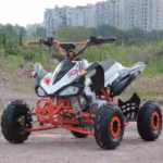 Quadriciclo esportivo ATV branco e vermelho em terreno de terra.