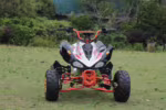 Quadriciclo esportivo ATV com quadro laranja e carroceria branca.
