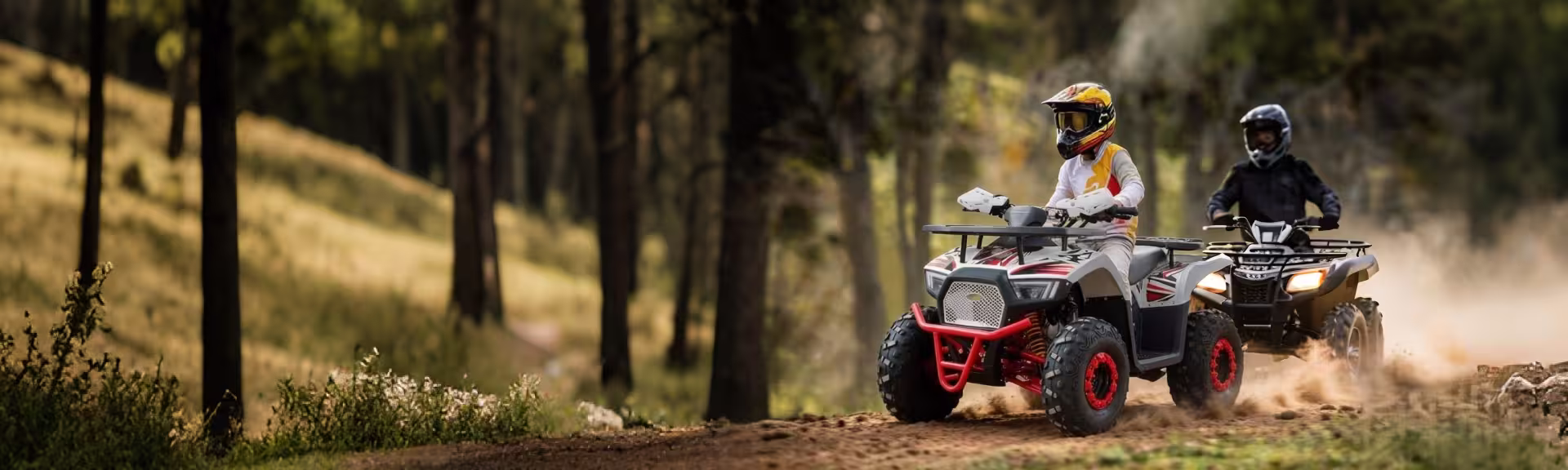Two riders driving ATVs on forest trail