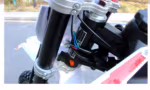 Primer plano del conjunto de la horquilla de suspensión delantera y el manillar de la motocicleta.