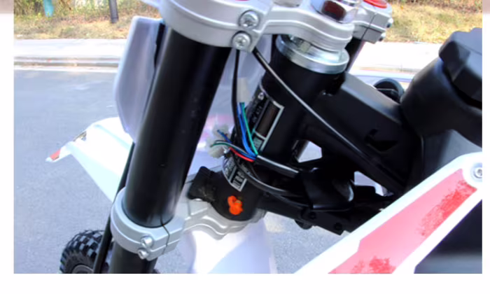 Primer plano del conjunto de la horquilla de suspensión delantera y el manillar de la motocicleta.