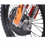 Detalle de la pinza de freno trasera y el piñón de la moto de cross