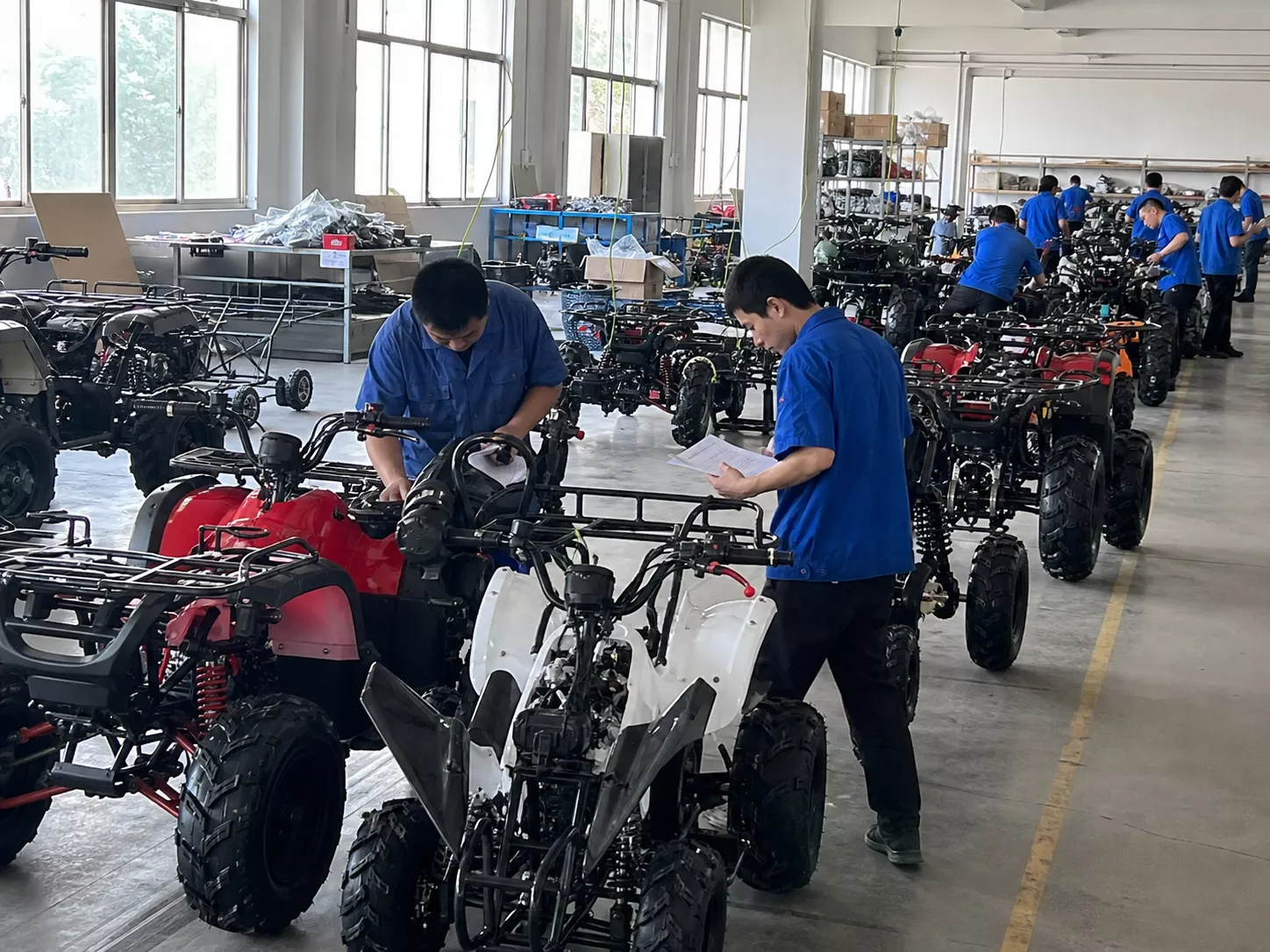 YKF MOTO ATV final inspection area with factory workers checking vehicles